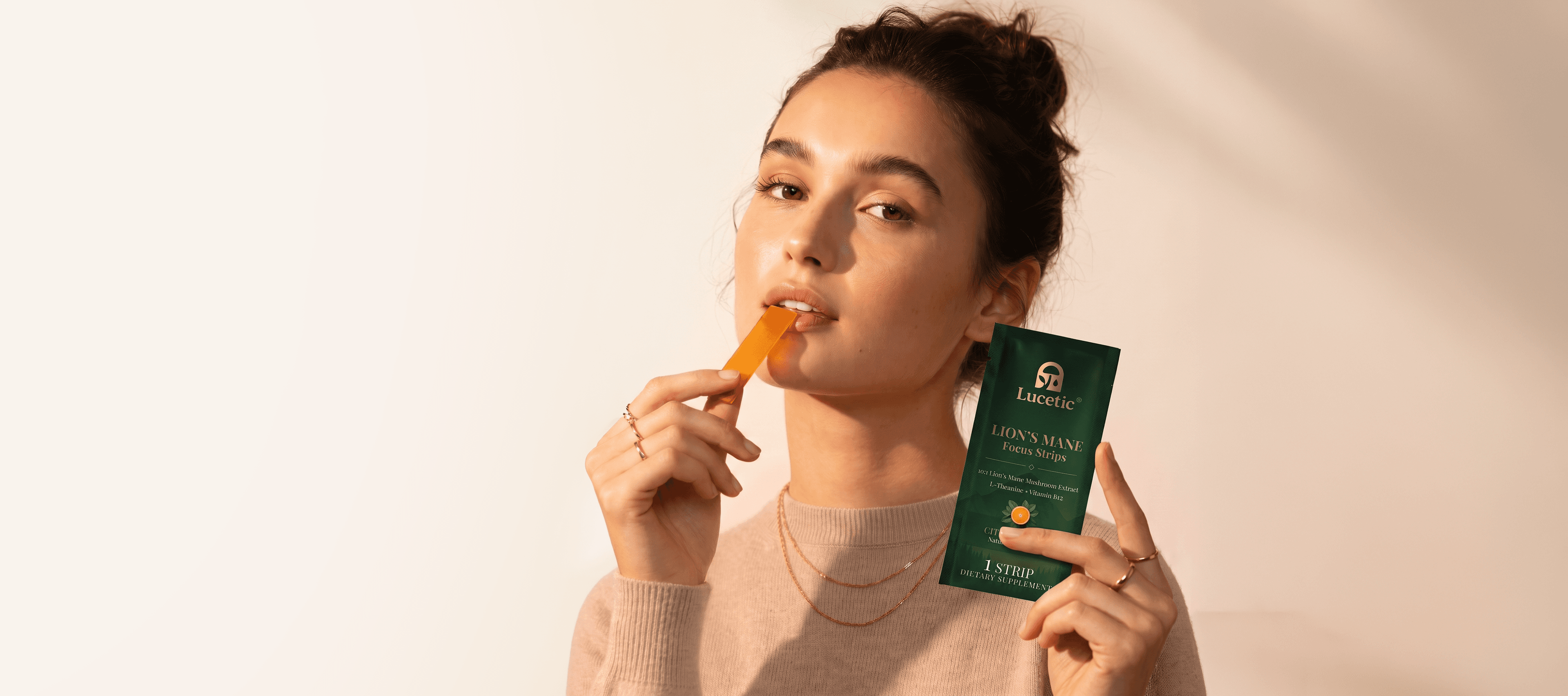 Woman taking a Lucetic Lion's Mane Focus Strip while holding the strips pack