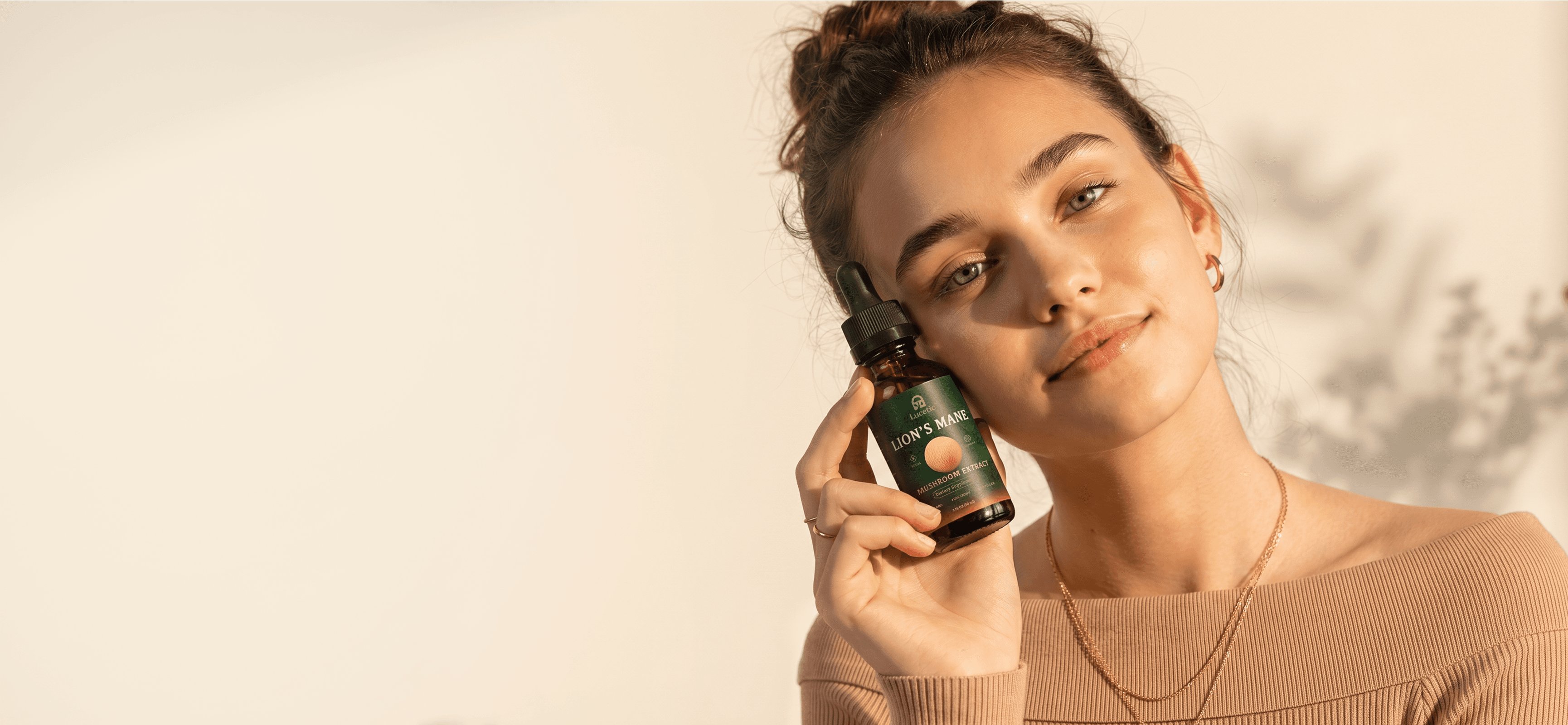 Woman holding a bottle of Lucetic Lion's Mane mushroom extract