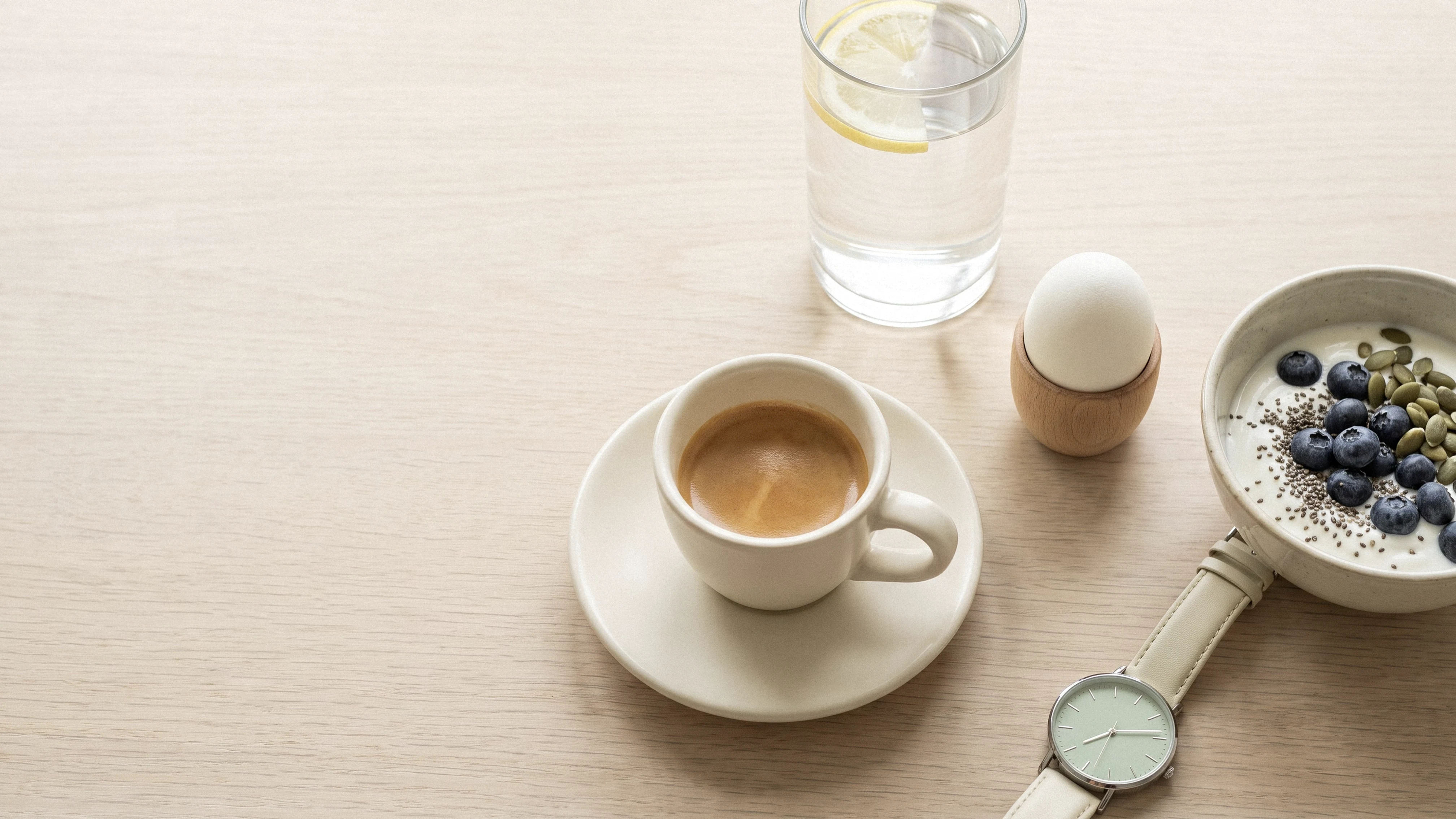 Small espresso, water, and protein breakfast on a wooden table